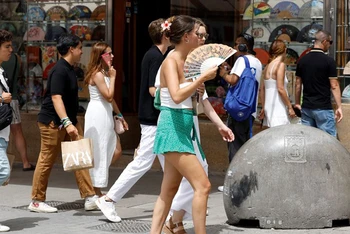 Người dân di chuyển dưới trời nắng nóng tại Madrid, Tây Ban Nha. (Ảnh: AFP/TTXVN)