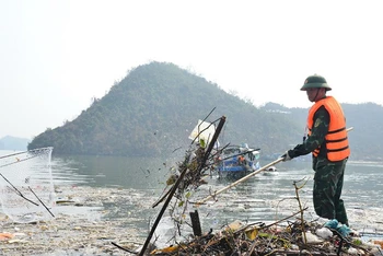 Thu gom rác tại khu vực vùng lõi Di sản Vịnh Hạ Long sau bão số 3. (Ảnh: TTXVN)