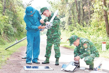 Cán bộ, chiến sĩ Ðồn Biên phòng Chi Lăng lắp đặt đèn năng lượng mặt trời trên đường tuần tra biên giới. 