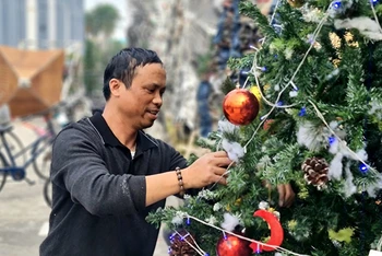 Giáo dân trang trí cây thông Noel tại Tiểu Vương cung thánh đường Phú Nhai, xã Xuân Phương, huyện Xuân Trường (Nam Ðịnh). 