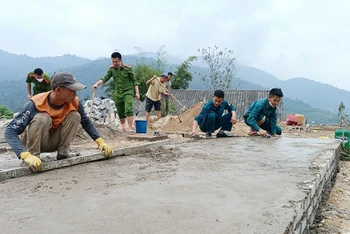 Công an xã Châu Thôn (huyện Quế Phong, tỉnh Nghệ An) hỗ trợ người dân xóm Tam Tiến xây dựng đường giao thông. (Ảnh QUỐC ÐẠT) 