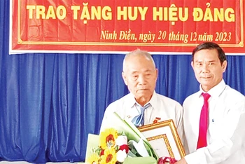 Ðồng chí Thân Văn Nhân, Phó Bí thư Thường trực Huyện ủy Châu Thành (Tây Ninh) trao Huy hiệu 55 năm tuổi đảng tặng đảng viên Lâm Văn Búp. 