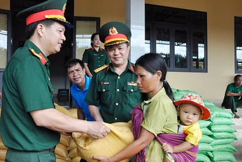 Ðại diện Công ty 74 (Binh đoàn 15, Bộ Quốc phòng) hỗ trợ gạo cho nhân dân. 