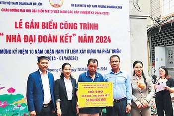 Ðại diện Ủy ban MTTQ - Ban vận động Quỹ "Vì người nghèo" quận Nam Từ Liêm trao hỗ trợ xây nhà "Ðại đoàn kết" tặng một hộ nghèo trên địa bàn. (Ảnh Trần Hòa) 