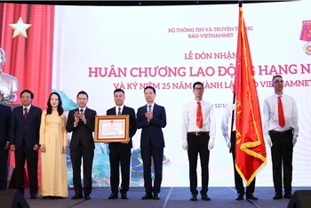 Đồng chí Nguyễn Mạnh Hùng (thứ 6 từ trái sang) trao Huân chương Lao động hạng Nhất tặng Báo VietNamNet tại buổi lễ.