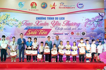Nguyên Phó Thủ tướng Thường trực Trương Hòa Bình (bên phải, hàng thứ hai) và Chủ tịch Hội Doanh nhân trẻ Việt Nam Đặng Hồng Anh (thứ 4 từ trái sang) trao quà tặng các em nhỏ có hoàn cảnh khó khăn.