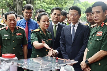 Đại tướng Phan Văn Giang (ngoài cùng bên phải) và các đại biểu tham quan khu vực trưng bày sản phẩm xuất sắc dự Giải thưởng Tuổi trẻ sáng tạo trong quân đội lần thứ 24.