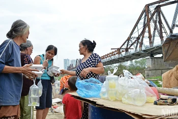 11 giờ sáng mỗi ngày, người dân tại xóm trọ lại tập trung để chia nhau những suất cơm do các đoàn từ thiện, nhà hảo tâm phát tặng.