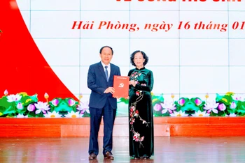 Đồng chí Trương Thị Mai, Ủy viên Bộ Chính trị, Trưởng Ban Tổ chức Trung ương trao Quyết định và tặng hoa chúc mừng đồng chí Lê Tiến Châu.