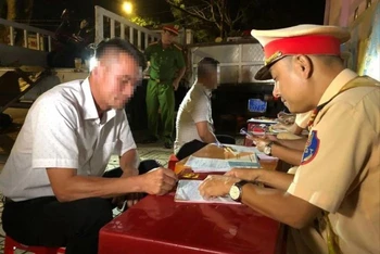 Lực lượng cảnh sát giao thông lập biên bản vi phạm của ông N.V.T vào tối 25/9. (Ảnh: Ngọc Hùng)