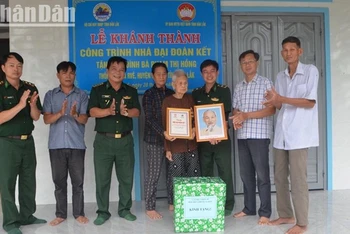 Đại diện Bộ Chỉ huy Bộ đội Biên phòng tỉnh Đắk Lắk và các đơn vị trao cờ Tổ quốc, ảnh Bác Hồ, biểu trưng và quà tặng gia đình bà Phạm Thị Hồng.