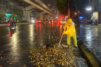 Công nhân Công ty Thoát nước Hà Nội thu dọn rác tại các cửa cống. 