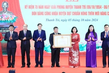 Phó Bí thư Thường trực Thành ủy Hà Nội Nguyễn Thị Tuyến trao Bằng công nhận huyện Thanh Trì đạt chuẩn nông thôn mới nâng cao cho lãnh đạo huyện Thanh Trì. (Ảnh: Quang Thái)