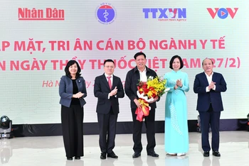 Tổng Biên tập Báo Nhân Dân Lê Quốc Minh và lãnh đạo các cơ quan báo chí chủ lực tặng hoa cho Thứ trưởng Thường trực Bộ Y tế Đỗ Xuân Tuyên nhân Ngày Thầy thuốc Việt Nam. (Ảnh: ĐĂNG KHOA)