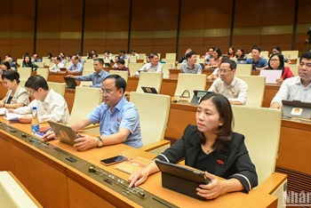 Các đại biểu Quốc hội bấm nút thông qua việc điều chỉnh Chương trình Kỳ họp thứ 9, Quốc hội khóa XV. (Ảnh: BÙI GIANG)