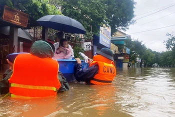 Cán bộ, chiến sĩ ngâm mình trong nước di dời người dân vùng ngập lũ ở Huế.