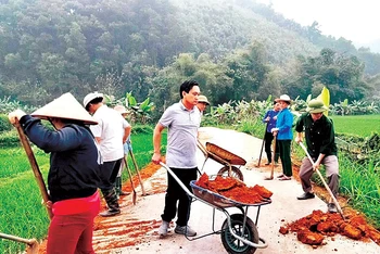Cán bộ huyện Yên Bình (tỉnh Yên Bái) tham gia tu sửa đường giao thông nông thôn trong hoạt động "Ngày cuối tuần cùng dân" tại thôn Nà Ké, xã Ngọc Chấn.