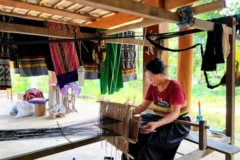 Công việc hằng ngày của bà Vi Thị Doanh (bản Ngàm, xã Sơn Điện) là dệt vải thổ cẩm và phục vụ khách tham quan.