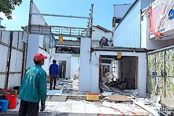 Căn nhà (bìa trái) sát nhà ông Cột, không có quyết định cưỡng chế nhưng bị cưỡng chế “nhầm”, chỉ còn phần vách. 