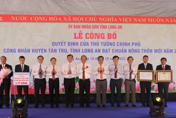 Nguyên Phó Thủ tướng Thường trực Chính phủ Trương Hòa Bình và lãnh đạo tỉnh Long An trao Quyết định của Thủ Tướng Chính phủ công nhận huyện Tân Trụ đạt chuẩn nông thôn mới.