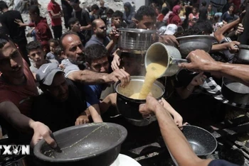 Người dân Palestine nhận thức ăn cứu trợ tại trại tị nạn Jabalia, miền bắc Dải Gaza ngày 19/5. (Ảnh: THX/TTXVN)