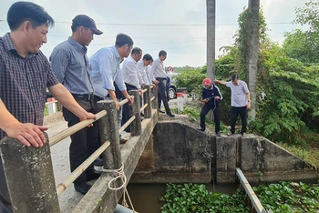 Ông Trương Cảnh Tuyên, Phó Chủ tịch thường trực Ủy ban nhân dân tỉnh Hậu Giang (bìa phải) kiểm tra nồng độ mặn tại cống Hóc Pó, xã Lương Nghĩa