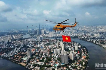 Trực thăng tập luyện bay kéo cờ trên bầu trời thành phố Hồ Chí Minh. (Ảnh: Khiếu Minh)
