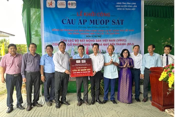 Nguyên Phó Thủ tướng thường trực Trương Hòa Bình cùng nhà tài trợ trao bảng tượng trưng kinh phí xây dựng cầu Mướp Sát. 