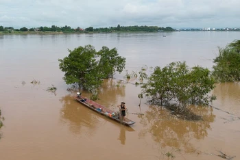 Một người dân đang đánh cá trên sông Mê Kông dọc theo bãi cát ngập nước, phía tây thủ đô Viêng Chăn của Lào.