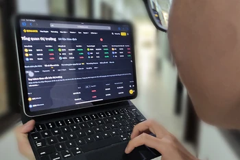Khách hàng theo dõi tiền ảo trên sàn giao dịch tiền điện tử Binance. (Ảnh ĐĂNG ANH)