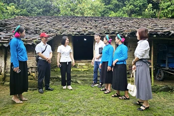 Khách du lịch tham quan nhà cổ của dân tộc Sán Chỉ ở Khu du lịch cộng đồng xã Đại Dực, huyện Tiên Yên, tỉnh Quảng Ninh. (Ảnh QUANG THỌ)