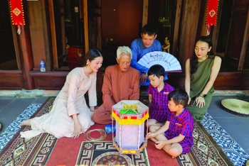 Nghệ nhân Nguyễn Văn Quyền (thứ hai từ trái sang; xã Cao Viên, huyện Thanh Oai, Hà Nội) giới thiệu cách làm đèn kéo quân. 