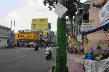 Quảng cáo rao vặt bán nhà đất dán đè lên phần cỏ nhựa gây mất mỹ quan.