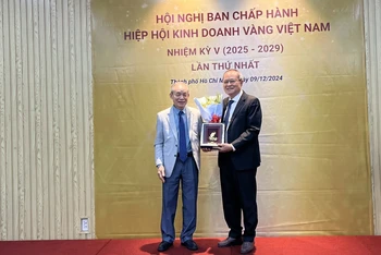 Tân Chủ tịch Hiệp hội Kinh doanh Vàng Việt Nam Đinh Nho Bảng (bên trái) tặng hoa và kỷ niệm chương cho Chủ tịch tiền nhiệm Nguyễn Thành Long.