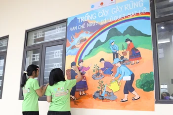 Các em học sinh Trường phổ thông dân tộc nội trú Trung học cơ sở và Trung học phổ thông huyện Bảo Thắng, tỉnh Lào Cai vẽ tranh tường.