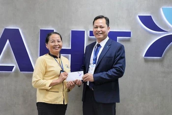 Đại diện Công ty cổ phần Đầu tư Khai thác Nhà ga quốc tế Đà Nẵng khen thưởng bà Trần Thị Hường.