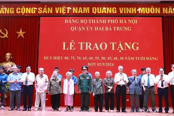 Đại diện Quận ủy Hai Bà Trưng trao tặng Huy hiệu Đảng và hoa chúc mừng 8 đồng chí đảng viên 75 năm, 70 năm tuổi đảng.