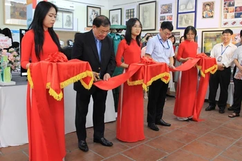 Hiệu trưởng Trường đại học Hòa Bình Tô Ngọc Hưng cắt băng khai mạc triển lãm.