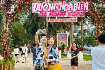 Du khách nước ngoài check-in tại Đường hoa biển Đà Nẵng chiều 30/4. (Ảnh: ANH ĐÀO)