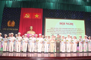 Đại diện lãnh đạo Bộ Công an và Công an tỉnh Hà Nam tặng biểu trưng và hoa cho các tập thể điển hình tiên tiến.