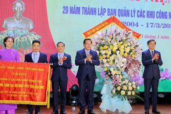Đồng chí Bí thư Tỉnh ủy Ninh Bình Đoàn Minh Huấn đã trao bức trướng với dòng chữ "Năng động-sáng tạo-hội nhập-phát triển bền vững" và tặng hoa cho Ban Quản lý các khu công nghiệp tỉnh. (Ảnh: ANH TUẤN)