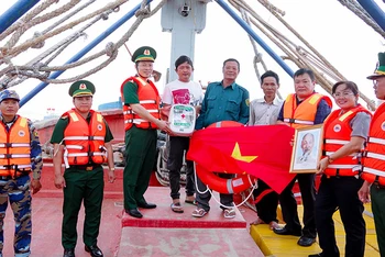 Tuần tra kiểm soát kết hợp tặng tủ thuốc Biên phòng, ảnh Bác Hồ, cờ Tổ quốc và phao cứu sinh cho chủ tàu cá.