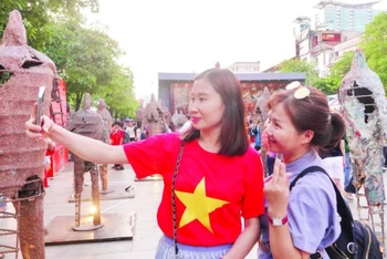Du khách thích thú với các hoạt động trong chuỗi sự kiện “Sắc màu thành phố Bác” tại đường đi bộ Nguyễn Huệ. (Ảnh MẠNH HẢO)