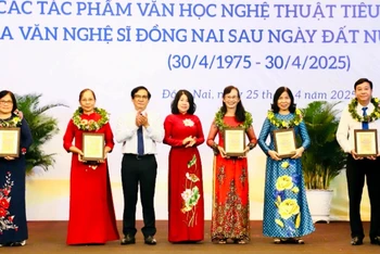 Phó Chủ tịch HĐND tỉnh Đồng Nai Hoàng Thị Bích Hằng và Phó Chủ tịch UBND tỉnh Nguyễn Sơn Hùng trao biểu trưng tôn vinh cho đại diện gia đình các văn nghệ sĩ.