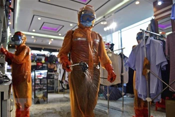 Phun thuốc khử trùng phòng dịch Covid-19 tại trung tâm thương mại ở Bình Nhưỡng, Triều Tiên. (Ảnh: Kyodo/TTXVN)