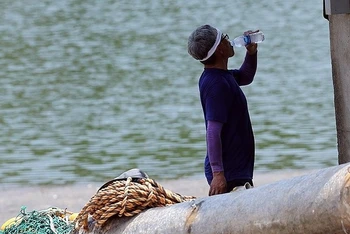 Công nhân uống nước lạnh giải nhiệt trong thời tiết nóng bức tại Hàn Quốc. (Ảnh: Yonhap)