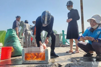 Tổ giúp dân phóng sinh cá của phường Nhật Tân được bố trí ngay khu vực đường Nguyễn Hoàng Tôn giáp hồ lớn nhất Thủ đô. (Ảnh: Sơn Bách)