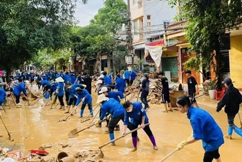 Thanh niên tình nguyện Yên Bái tham gia vệ sinh môi trường tại thành phố Yên Bái sau khi báo chão số 3 đi qua. (Ảnh: THANH SƠN)