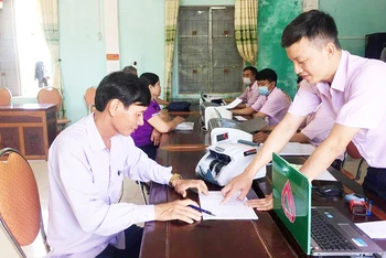 Cán bộ Ngân hàng Chính sách xã hội huyện Kỳ Anh hướng dẫn người dân làm thủ tục tại điểm giao dịch xã.