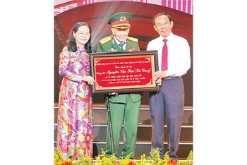 Đồng chí Nguyễn Văn Nên, Ủy viên Bộ Chính trị; Bí thư Thành ủy Thành phố Hồ Chí Minh trao bảng tôn vinh Đại tá, Anh hùng Lực lượng Vũ trang nhân dân Nguyễn Văn Tàu (Tư Cang).